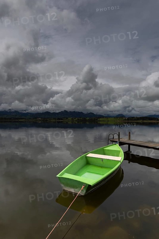 Storm clouds at sunset, a green rowing boat lashed to the wooden jetty, Hopfensee, Hopfen am See, near Füssen, Ostallgäu, Allgäu, Bavaria, Germany