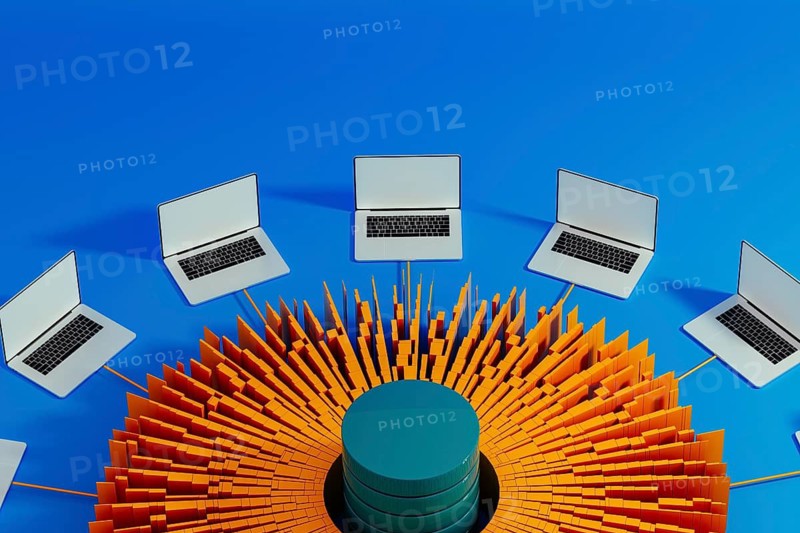 Multiple laptops surround a central data hub, showcasing technology integration for artificial intelligence advancements in a modern workspace