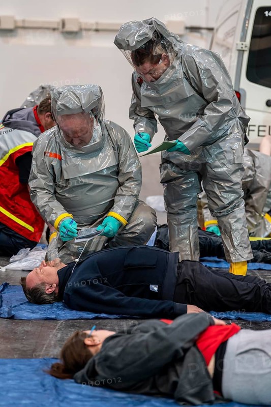 Viewing of patients in front of decontamination of injured persons after an assumed accident with hazardous substances, patient is intubated and ventilated by hand, fire brigade and aid organisations practise setting up and operating a decontamination station, injured persons are viewed and then washed in a special shower tent to remove possible hazardous substances and chemicals in order to avoid further injuries, the emergency services wear special, ventilated protective suits, large-scale exercise by the Essen fire brigade