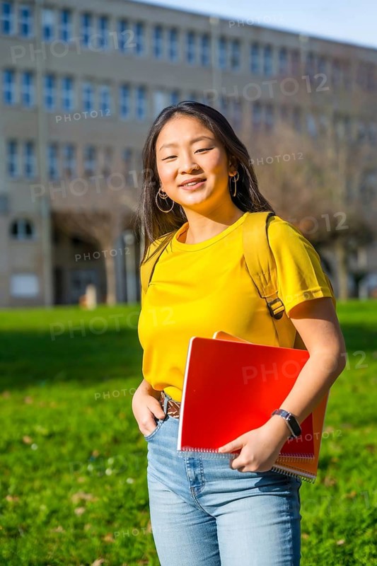 Vertical portrait of an asian student in the campus of the university