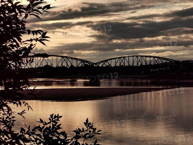 Landscape with a bridge in the background at sunset with dramatic clouds