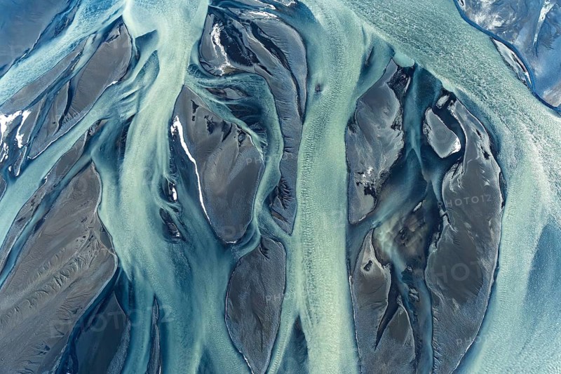 Stunning aerial drone image capturing the intricate patterns and vivid colors of river deltas along Iceland's coast, showcasing nature's artwork in earthy tones