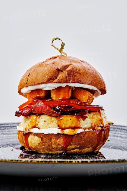 Close up view of burger with beef, bacon, pumpkin and tomato