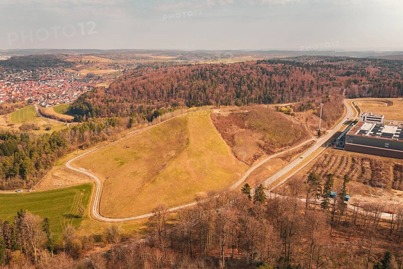 Hilly landscape with adjacent town and vast forest areas, viewed from above, old deposit in front of PV Bau, Lindenrain, Calw, Germany