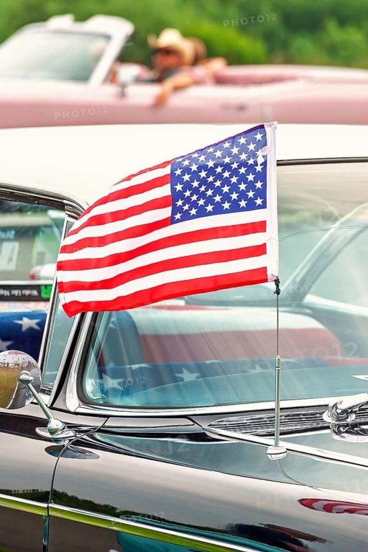 Classic vintage car with a American flag attached to the antenna, waving in the breeze, USA