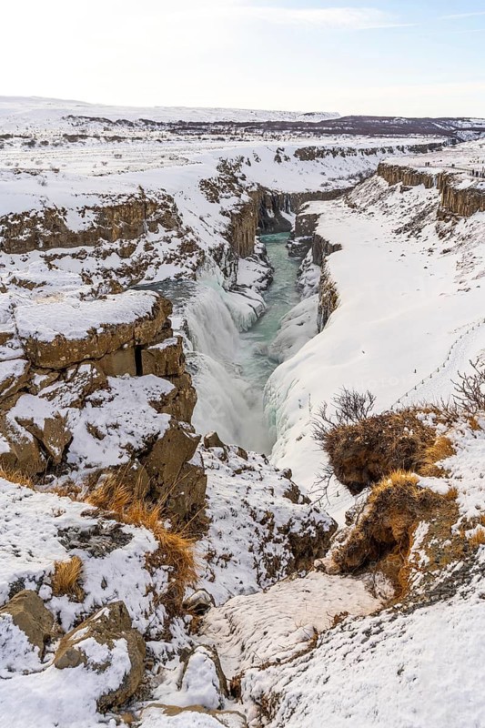 Beautiful snowy Gullfoss waterfall in the cold Icelandic winter without people, vertical photo