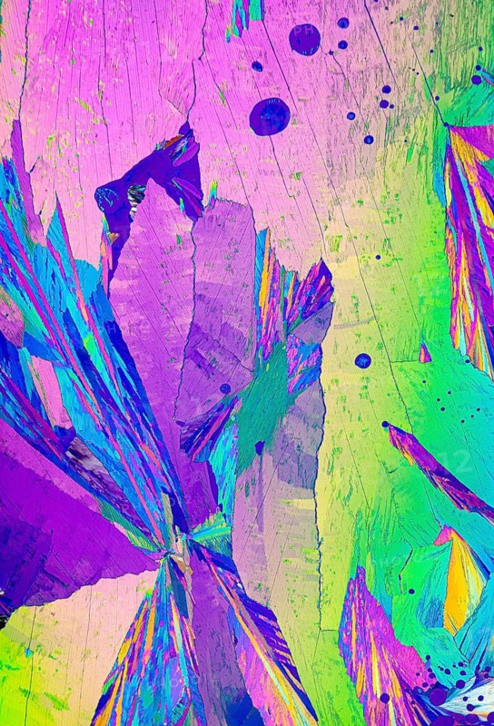 A vivid microscope image showcasing Adipic acid, crystals. This photo features a kaleidoscope of colors including luminous pink, vibrant green, deep violet, and hints of blue and yellow