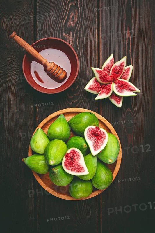 Fresh green figs, honey, top view, on a wooden table, no people