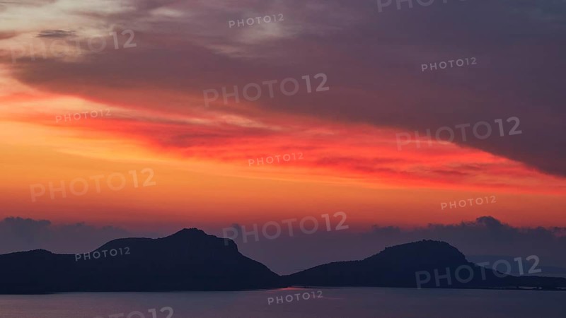 Red illuminated sky over a seascape with islands, Navarino Bay, Pylos, Peloponnese, Greece