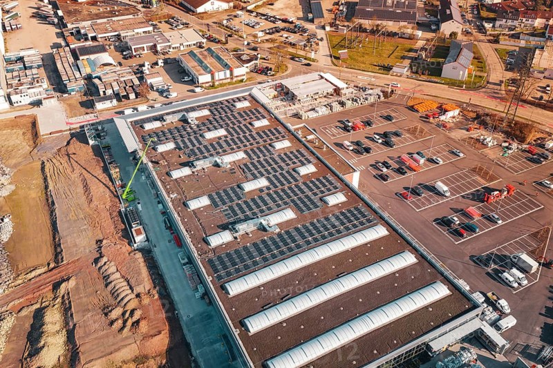 Large industrial building with solar panels and adjacent parking lot in an urban landscape, PV Bau Auf OBI Bau Markt, Mühlacker, Enzkreis, Germany