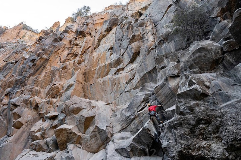 Two climbers tackles a challenging ascent on a rugged rock face, showcasing the adventurous spirit of traditional climbing in a breathtaking natural environment
