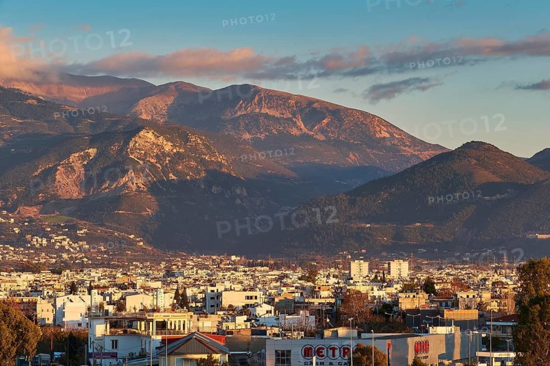 City view at sunset with mountains in background and cloudy sky, Patras, Peloponnese, Greece