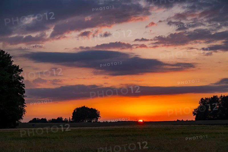 Romantic sunset over fields and meadows with colorful clouds in early summer, Upper Palatinate, Bavaria, Germany