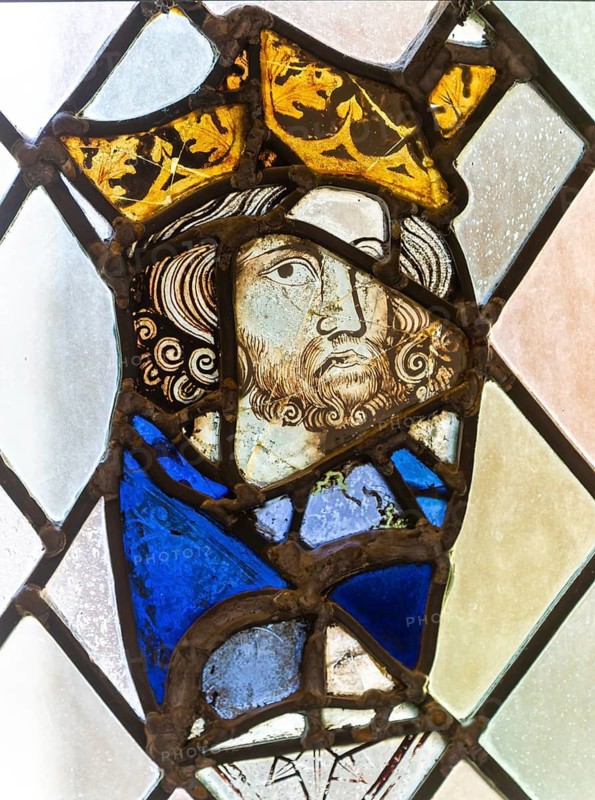 Stained glass window depiction of medieval man face, Bristol cathedral church, Bristol, England, UK