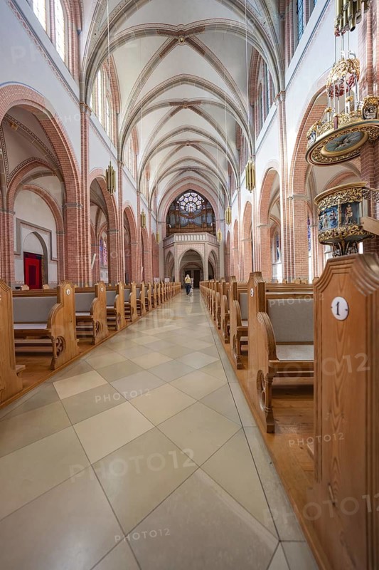 Long church corridor with high vaults and glass windows, wooden benches left and right, Sacred Heart Cherry, Bregenz, Austria