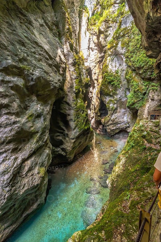 Turquoise water flowing between narrow rock walls at the bottom of tolmin gorges canyon in triglav national park, slovenia
