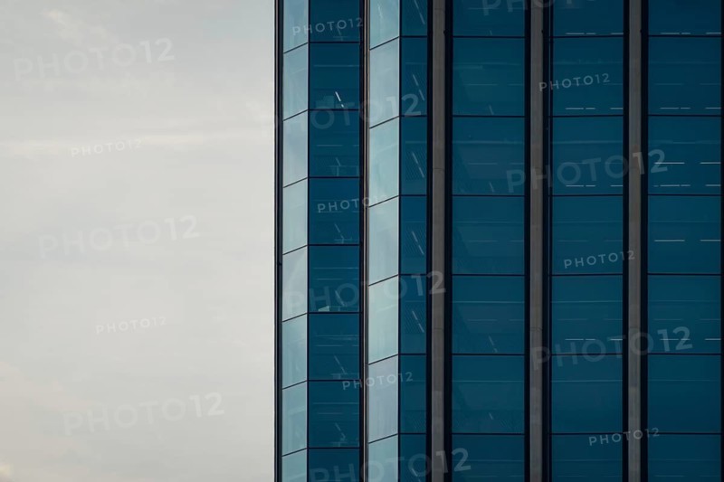 A striking image of a modern building featuring a blue glass facade, captured under a clear sky in Colon City, Panama. This photo showcases the distinctive architecture and urban style of the region