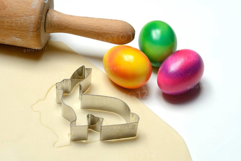 Rolled dough with bunny cookie cutter, rolling pin and Easter eggs