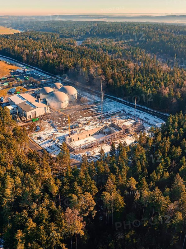 Bird's eye view of industrial building and construction site in the snowy forest, new fire station, Oberhaugsett, Calw district, Germany