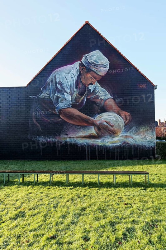 Mural, baker rolls loaf of bread in flour, baker's craft, mural by street artist SMOKE, Bruges, West Flanders, Flanders, Belgium