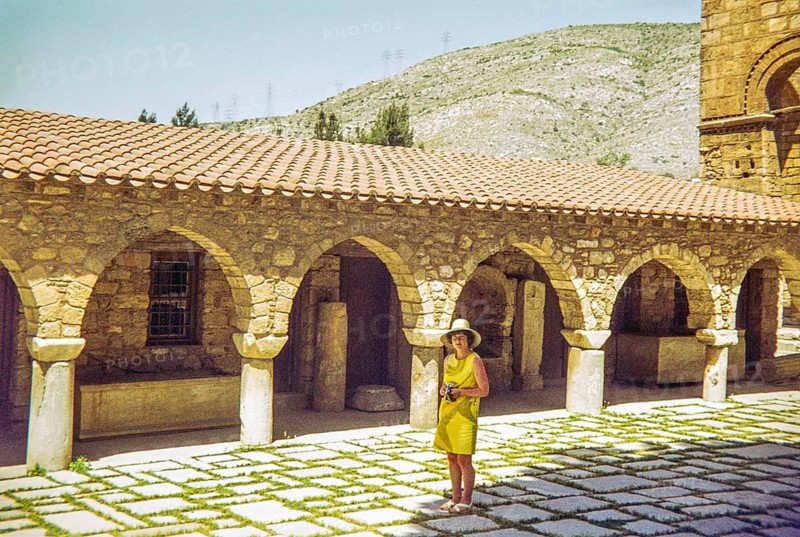 Woman tourist standing by peristyle Byzantine architecture of arches at Daphni Monastery, Chaidari, Athens, Greece, Europe 1972