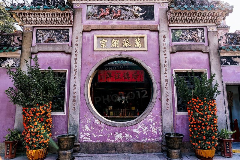A colorful and culturally rich Taoist and Chinese Buddhist temple facade in Macau, adorned with historical architectural details and vibrant decorations