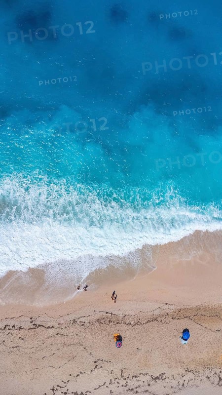 Aerial drone aerial shot in summer on paradise sandy beach Megali Petra in Lefkada. Beautiful crystal clear turquoise and blue waters. Greece. vertical photo