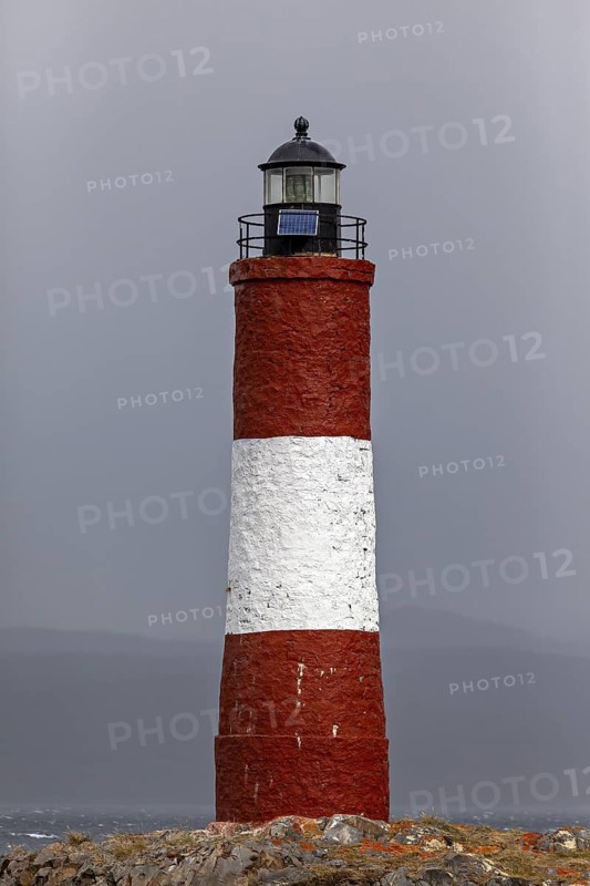 Close-up of a red and white lighthouse in front of a cloudy sky, The lighthouse in the Beagle Channel near Ushuaia in Argentina