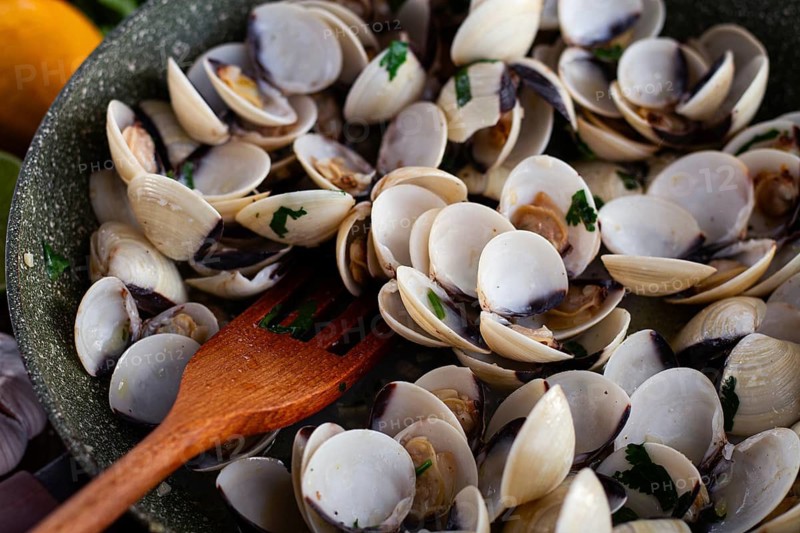 Cooking, vongole clams, in a pan with spices and white wine, top view, no people