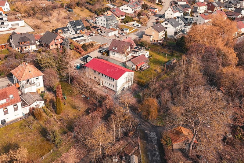 House with a distinctive red roof in a residential area surrounded by gardens and trees, Ötisheim, Enzkreis, Germany