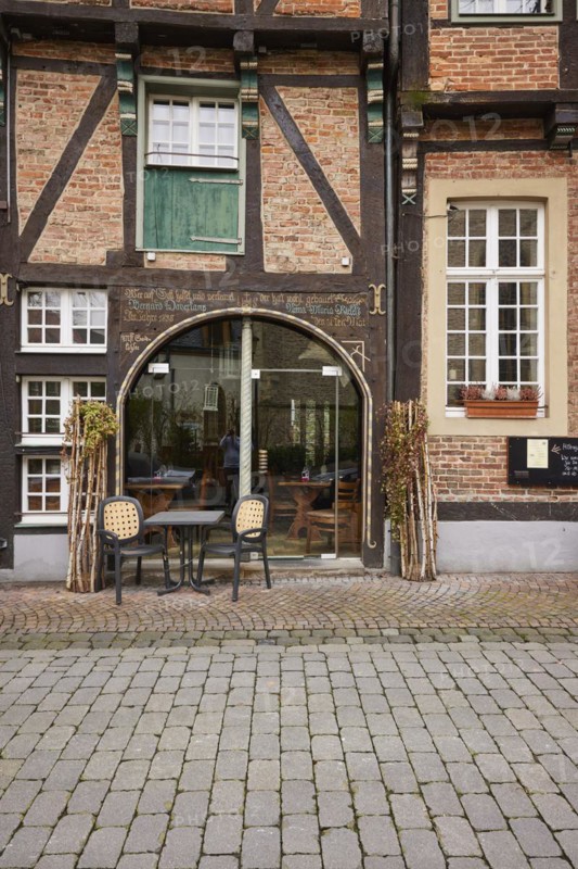 Entrance area of a restaurant in a historic half-timbered brick house with white, divided windows in the old town centre of Warendorf, Warendorf district, North Rhine-Westphalia, Germany