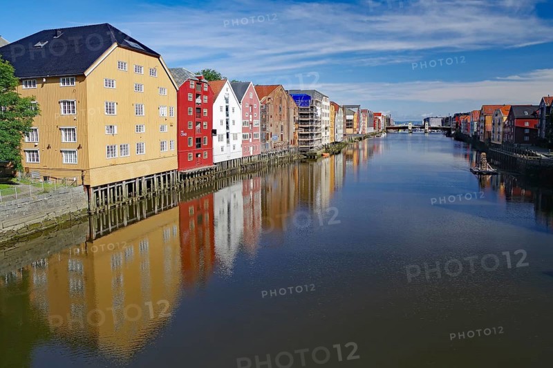 Colourful buildings reflected in the calm water of a river under a blue sky, Nidelva, Trondheim, Tröndelang, Norway