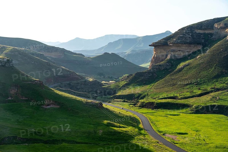 Road through grasslands with sandstone cliffs and cliffs, landscape in Golden Gate Highlands National Park, Free State, South Africa