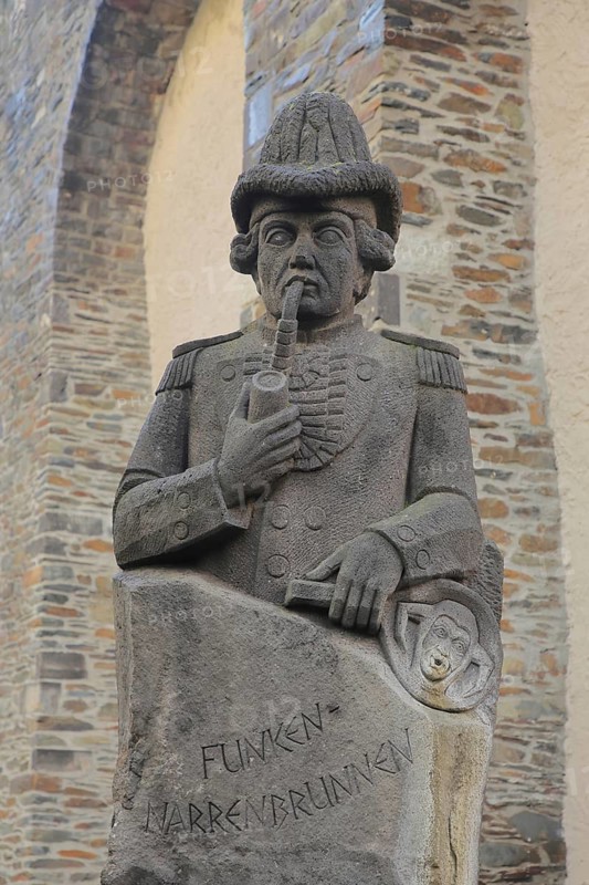 Stone sculpture with pipe in mouth and inscription, spark fools fountain in memory and memorial of historic carnival, Andernach, Rhineland-Palatinate, Upper Middle Rhine Valley, Germany
