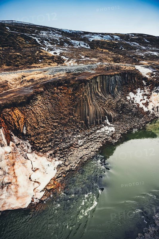 Stunning basalt columns along the turquoise river in Studlagil Canyon, Iceland. This breathtaking natural wonder showcases Iceland's unique geological formations