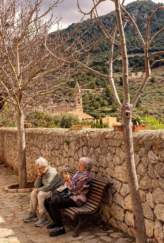 Senior women enjoying a break on a park bench, Valdemossa City Walls, Majorca, Balearic Islands, Spain