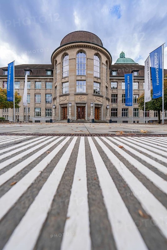 Magnificent building with dome, flanked by blue flags and dramatic sky, Zurich, Switzerland