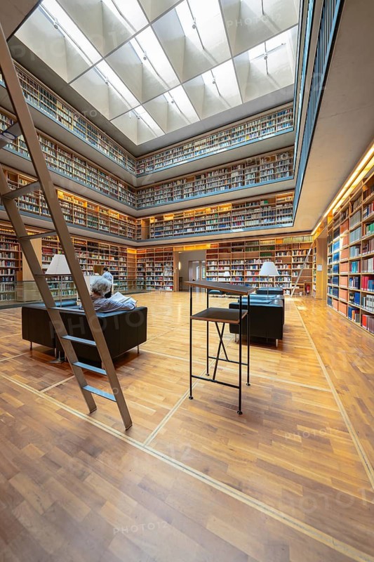 Modern library with high bookshelves, reading area and large windows, Weimar, Germany