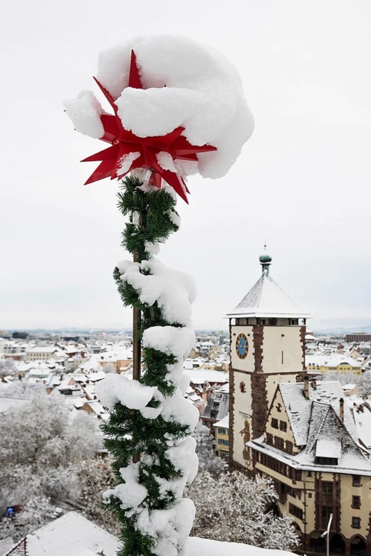 Snow-covered star and houses in the historic city centre, Freiburg im Breisgau, Black Forest, Baden-Württemberg, Germany