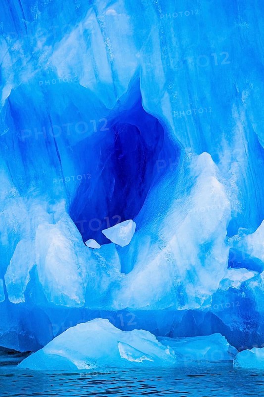 Cave into a glacier by the sea with turquoise colored ice, Svalbard, Norway