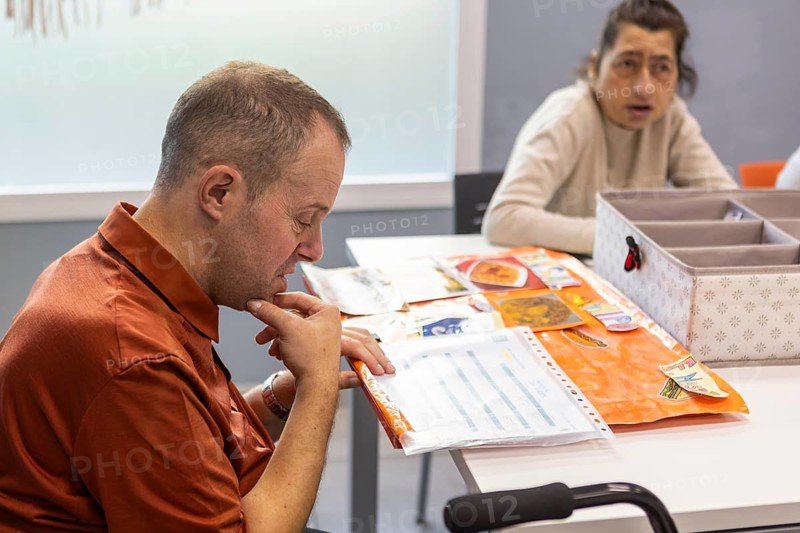 Individuals engage in meaningful activities at a day center for intellectual disabilities. The setting fosters learning, creativity, and social interaction in a supportive environment