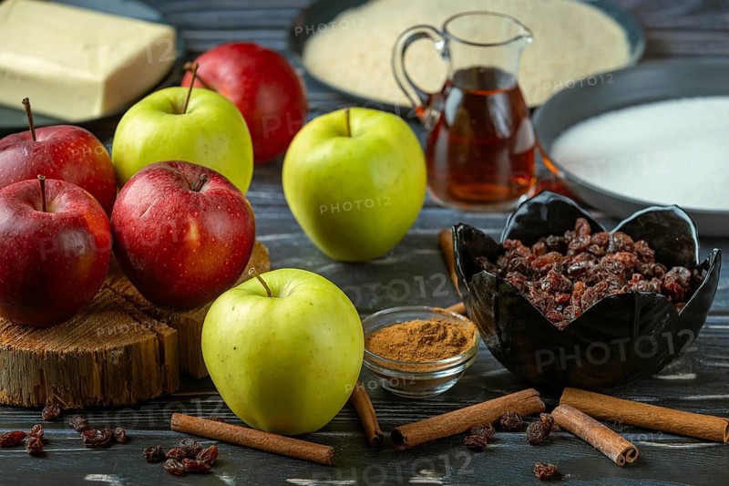 Various baking ingredients such as apples, cinnamon, sugar, rum and raisins