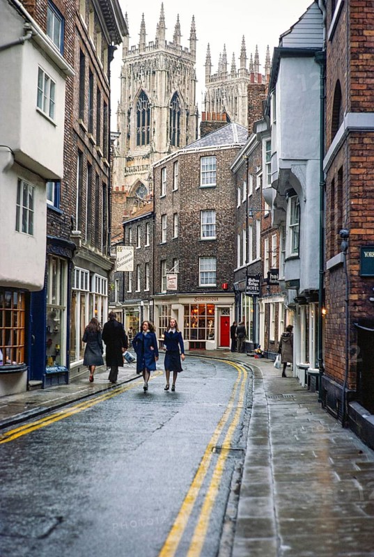 Spaziergänger in der historischen Low Petergate Straße in der Nähe der Yorker Münsterkirche, Yorkshire, England, UK 19. November 1975