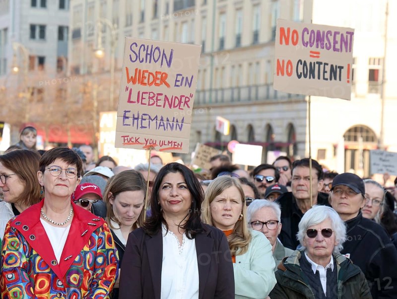 Politicians Saskia Esken and Derya Türk-Nachbaur (both SPD) in front of signs Schon wieder ein 'liebender' Ehemann / Fuck You Ulmen and No Consent = No Content! at the demonstration Gegen sexualisierte digitale Gewalt - Solidarität mit allen Opfern on Pariser Platz in Berlin on 22.03.2026