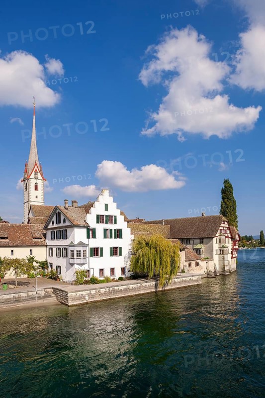 Half-timbered house and church tower on a clear river under a blue sky, view of the old town of Stein am Rhein with St. George's Monastery, Stein am Rhein, Canton Schaffhausen, Switzerland