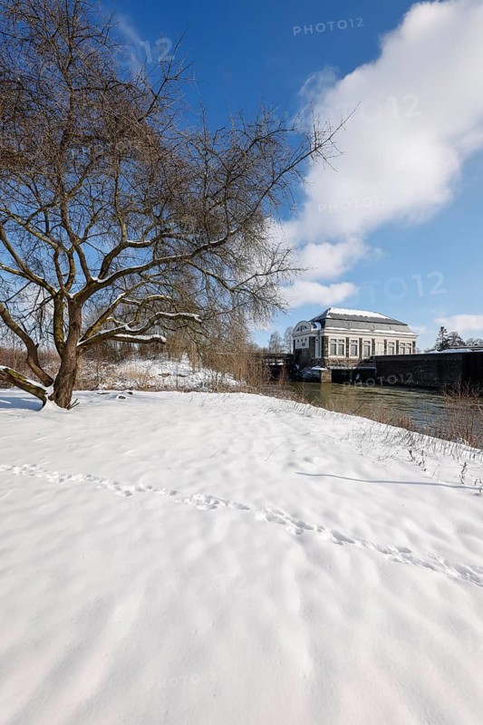 Hamm, North Rhine-Westphalia, Germany - Sunny winter landscape in the Ruhr area, ice and snow on the river Lippe, behind the building of the water transfer Hamm between the river Lippe and the Datteln-Hamm canal