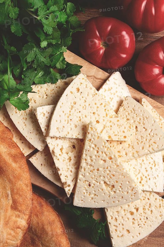 Georgian sliced cheese, on a wooden chopping board, with tomatoes with herbs and lavash, rustic style, Georgian cuisine, no people