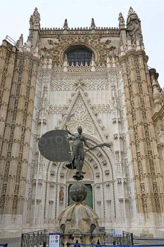 Impressive Gothic façade with a bronze statue of King John in front of the cathedral, Seville, Andalusia, Spain
