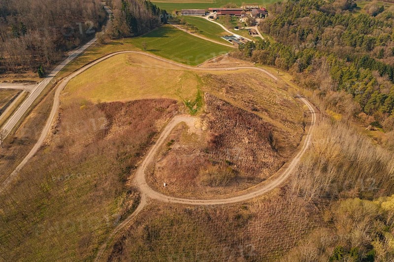Aerial view shows winding roads over a hill surrounded by fields and trees, old deposit in front of PV Bau, Lindenrain, Calw, Germany