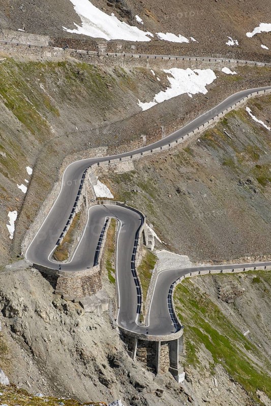 View of very steep mountain face with narrow serpentines hairpin bends from 2758 metres high highest pass road in Italy winding mountain road Alpine pass Stelvio Pass, Stelvio, South Tyrol, Alto Adige, Italy